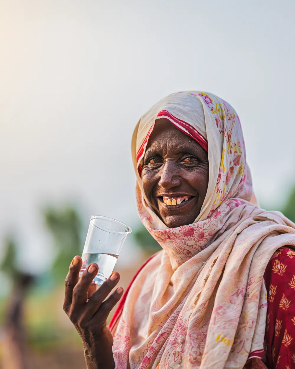 A woman holding the first glass of clean water her family has had