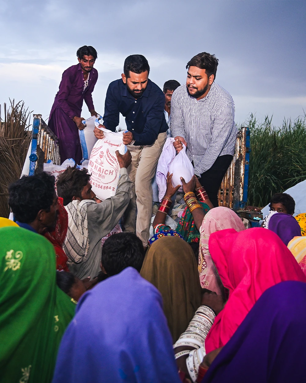 Ration sacks handed down from a truck to flood-affected families in Sindh