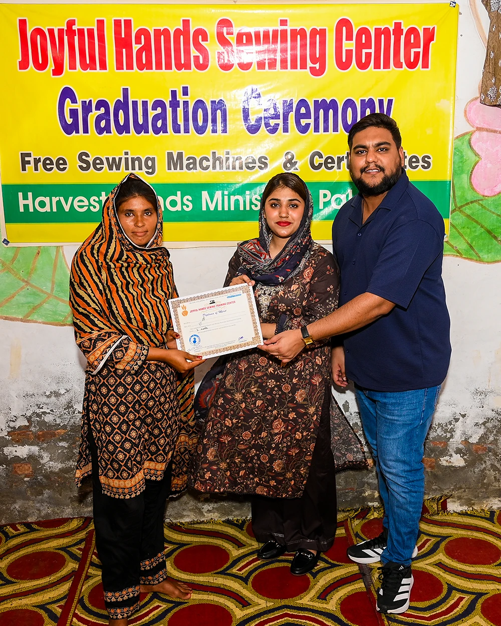 A graduate receiving her certificate at the Joyful Hands Sewing Center ceremony