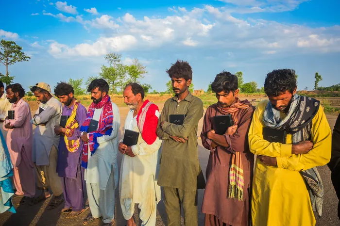 Men holding the Bibles they have just been given
