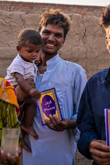 A father holding his child and his first Bible