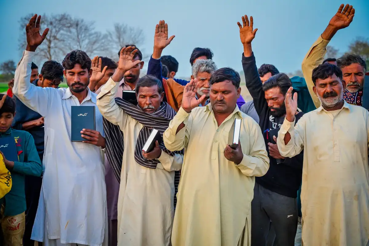 A village raising the Bibles they have just received