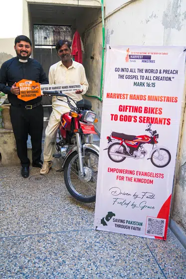 A pastor with the motorbike he was given